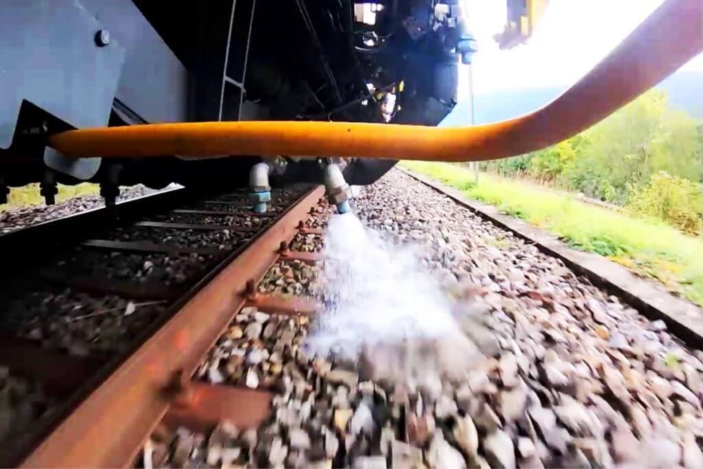 SBB train spraying hot water on vegetation
