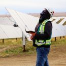 PCL drone pilot looking up amidst solar panels