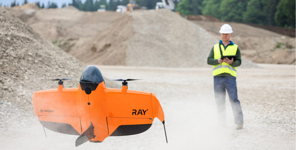 Piloto de dron y topógrafo en cantera aterrizando el dron de topografía y mapeo WingtraRAY.