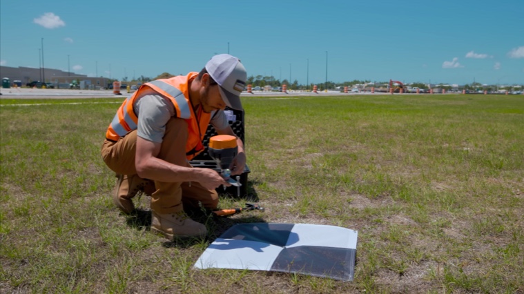 Géomètre installant un point de contrôle pour le levé par drone
